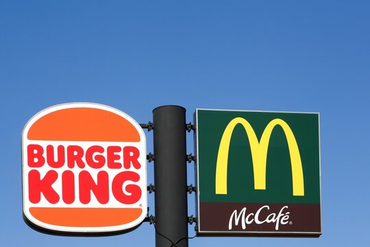 Vejle, Denmark - March 15, 2025: McDonald's logo and Burger King logo on a pole. McDonald's and Burger King are two of the world's largest chain of hamburger fast food restaurants