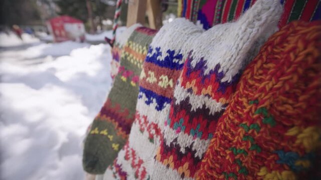 Various hand-crafted woolen socks with decorative patterns and vibrant colors on display in an artisan market in Bansko, Bulgaria