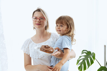 A mother giving her child a chocolate-glazed donut, an unhealthy feeding practice 