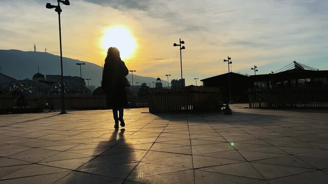 Silhouette of a woman walking during sunset on Skanderbeg square in Skopje, Macedonia