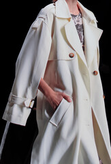 Fashion classy details of long white coat, fancy cloth on black background