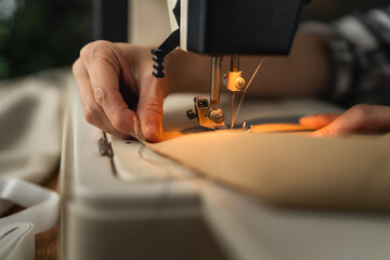 Hands sewing fabric with an electric sewing machine