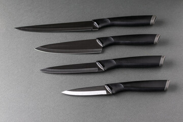Sleek Black Kitchen Knives on Gray Background: Modern Culinary Tools and Cutlery Design