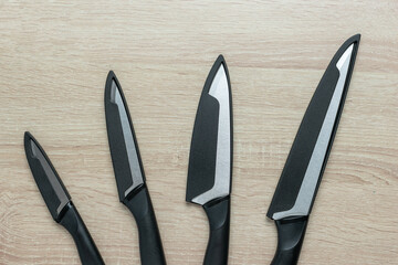 Set of Black Ceramic Kitchen Knives on Wooden Surface