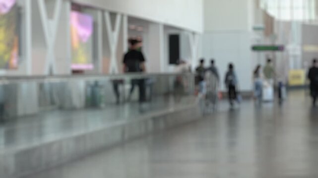 Bokeh view of passengers in departure zone of International airport Lapangan Terbang Antarabangsa Kuala Lumpur, Sepang, Selangor, Malaysia. Blurred background footage.