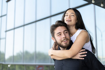 Man carrying a woman on his back and laughing.