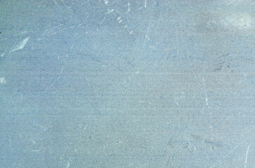 Close-up texture of a scratched brushed metal surface with a cool blue-grey tone