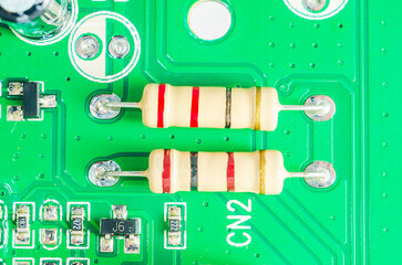 Close-up view of two resistors on a green printed circuit board with intricate details