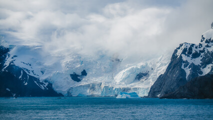 Glacier in Antarctica Runs into Ocean in Remote Fine Art Photography. Clouds Roll in Powerful Nature Scene View From Ship. Elephant Island © And They Travel