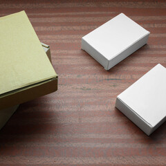 three white cardboard boxes on a wooden table surface