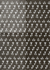 Abstract geometric pattern featuring scattered white triangles on a black textured fabric background. The repeating design has a modern, minimalist, and slightly retro feel.