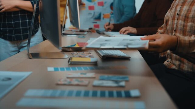 A vibrant and engaging creative workspace where professionals collaborate on design projects, using technology to brainstorm ideas and enhance teamwork. SACTR