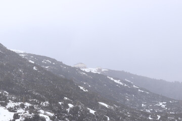 Beautiful snowy landscapes with mountains. Rila National Park, Bulgaria. Winter landscape, snow-covered ground, cloudy sky, mountains. Snowfall in the mountains. Natural landscape in winter