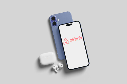 Smartphone displaying airbnb app with wireless earbuds