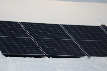 Solar panels partially covered in deep snow during winter