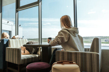 Digital nomad woman using smartphone in modern airport terminal, remote work and solo travel lifestyle,mobile office concept, freelance productivity, location independent work, modern travel routine.