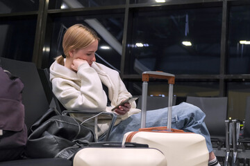 Digital nomad woman using smartphone in modern airport terminal, remote work and solo travel lifestyle,mobile office concept, freelance productivity, location independent work, modern travel routine.