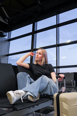 Digital nomad woman using smartphone in modern airport terminal, remote work and solo travel lifestyle,mobile office concept, freelance productivity, location independent work, modern travel routine.