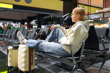 Digital nomad woman using smartphone in modern airport terminal, remote work and solo travel lifestyle,mobile office concept, freelance productivity, location independent work, modern travel routine.