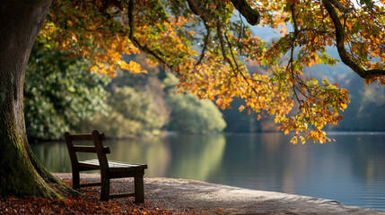 Naklejka premium Peaceful lakeside scene with empty wooden bench surrounded by vibrant autumn leaves and trees reflecting in calm water, seasonal tranquility, with copy space
