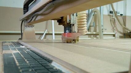 Cnc router machine milling wooden panel in workshop