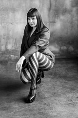 Body positive concept. Sexy elegant beautiful gorgeous self confident plus size middle age woman in a violet suit and tights