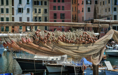 Fishing nets with buoys dry in port of the fishing town of Camogli in Italy