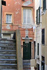 colorful streets of the fishing town of Camogli in Italy, stairs and windows with curtains and laundry drying