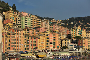 Colorful buildings are densely packed on a hillside by the sea, creating a recognizable Mediterranean landscape.