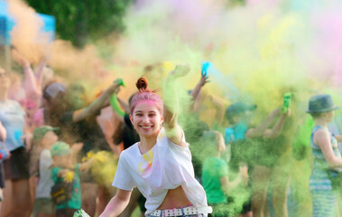 Girl Dancing Amidst Vibrant Colored Powder On Holi Festival