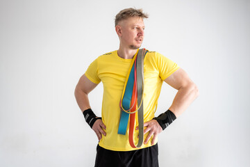 Sporty Man Holding Resistance Rubber Bands For Home Training On A White Background