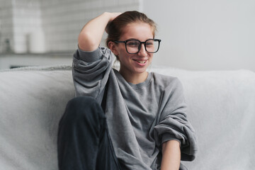 Happy Laughing Girl In Glasses On The Sofa In A Light Room