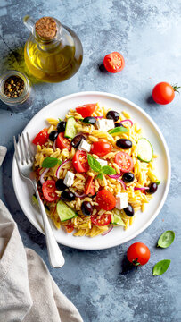 Griechischer Orzo-Salat mit Tomaten, Oliven, Feta und Basilikum als gesundes Essen