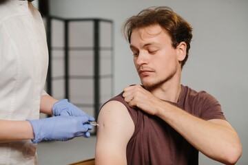 Obraz premium Person receiving vaccination looking serious at clinic