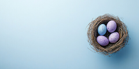 Top view of small easter nest with purple painted eggs on blue background with copy space