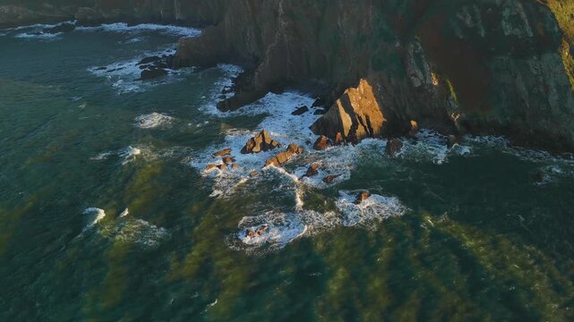 Cliff coastline with ocean waves at sunset, Spain