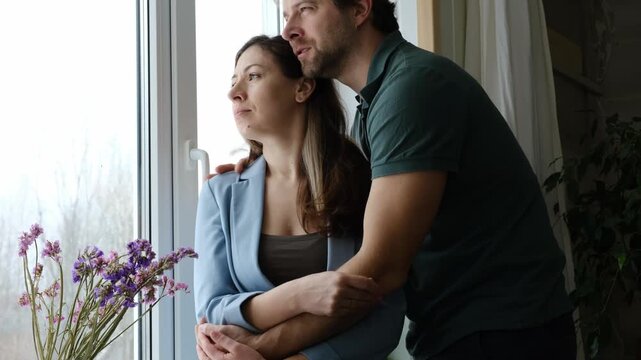 Mature couple hugging hugging each other kissing at home bedroom. Intimate Moment. Tender embrace shared between a loving middle age man and woman, husband and wife. Deep love. Low key, cinematic.