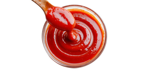 A glossy, bright red ketchup sauce swirls in a clear glass bowl, with a wooden spoon lifting a dollop.