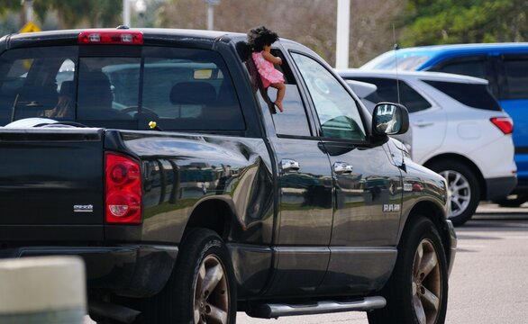 St Petersburg, Florida, U.S - Jan 3, 2026 - A black Dogde Ram Sport pickup truck with body damage features a doll hanging from the rear passenger side window