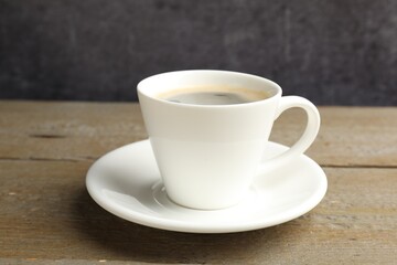 Obraz premium Cup of aromatic coffee on wooden table, closeup