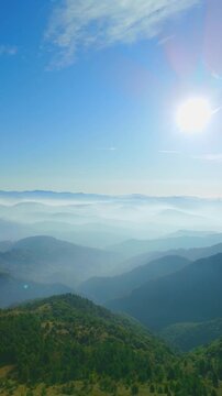Aerial landscape view of sunlit fog and mountain valley, Ceranesi, Italy, vertical video