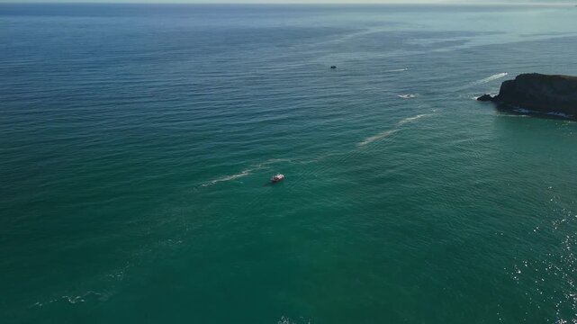 Boat on open ocean near rocky coast in northern Spain