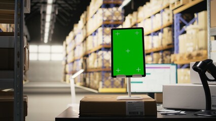 Order fulfillment modern desk with chroma key on a tablet in distribution hub, retail import export activity. Industrial space for barcode tracking and inventory control systems. E-commerce.