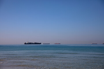 Fototapeta premium cruise ship in the sea, Cargo Ships on the Horizon during Calm Sunset