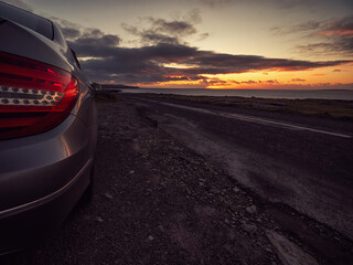 Car parked off road in wild nature setting at calm peaceful sunset. Travel and transportation....