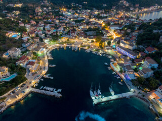 Fototapeta premium Night view of coastal town harbor, boats and lights.