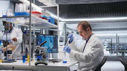 Male scientist handles pipette with droplet over jar during procedure in the lab. Mixture preparation supporting genetics research, nanotechnology and solutions through analytical methods.