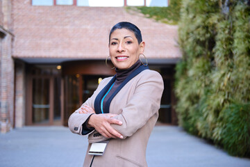 Fototapeta premium Confident mature latina businesswoman standing with arms crossed
