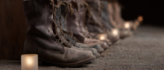 Row of worn leather boot memorial tribute candlelight vigil fallen soldier honor rustic footwear dusty floor name tag military reminder somber mood remembrance