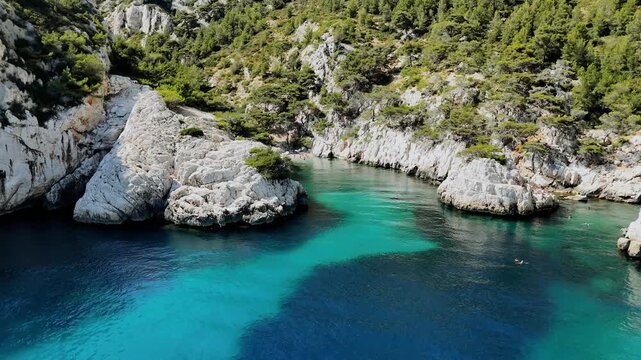 Vue a&eacute;rienne d'une baie aux eaux cristallines et falaises rocheuses 